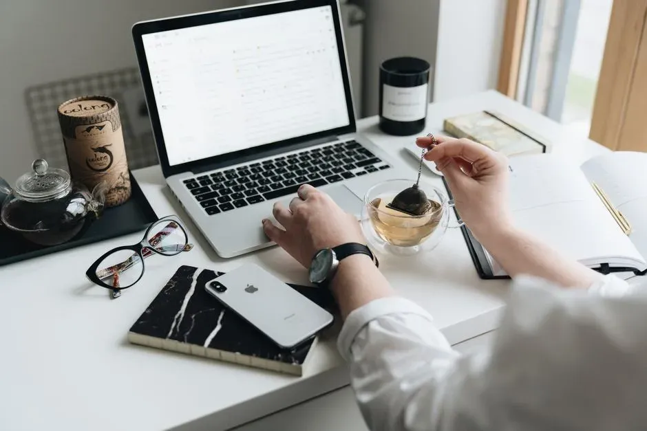 Un bureau calme avec ordinateur portable, agenda et tasse de thé pour organiser ses séances.